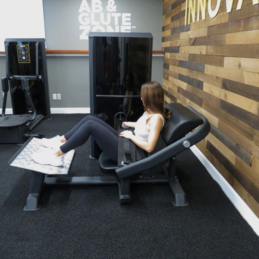 Female athlete using the machine in agym shown in the exercise start position