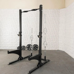 Squat stand shown in gym with optional bars loaded on rack