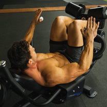 Athlete using bench shown from top side angle in crunch position