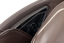 close up on integrated speaker located next to the chair headrest