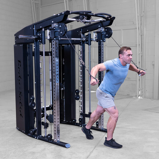 Male athlete performing cable crossover exercise using fuctional trainer component