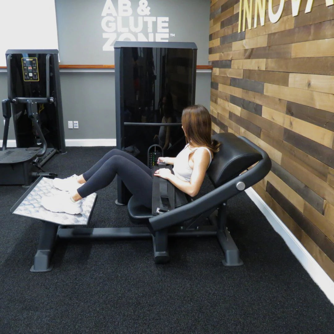 Female athlete using the machine in agym shown in the exercise start position