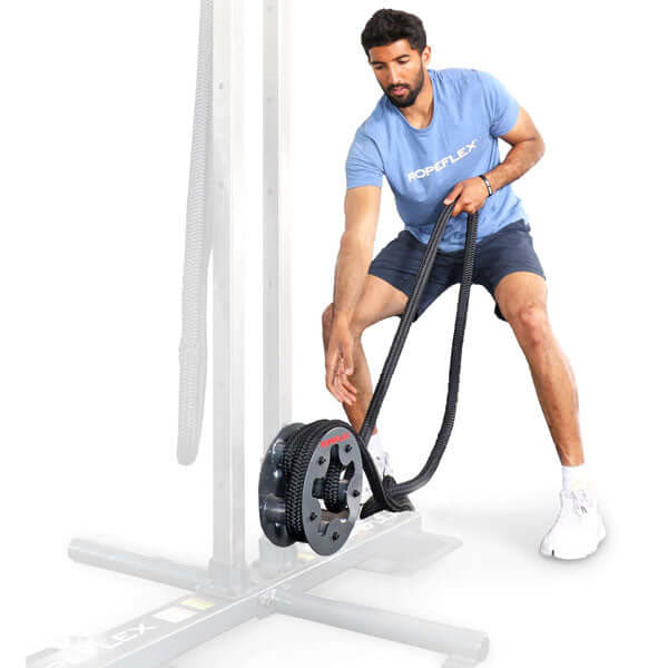 Athlete using the rope pulling drum in low position on a power rack