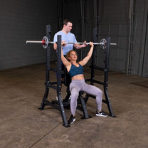 Olympic Shoulder Press Bench|Bench loaded with weights|In use|Safety crash bars|Seat back rest|Spotter Platform