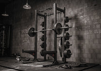 Half Rack shown in gym withg optional weight plates, bar, and chains
