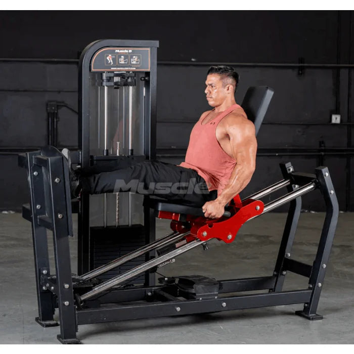 man using leg press machine in black frame with red highlights